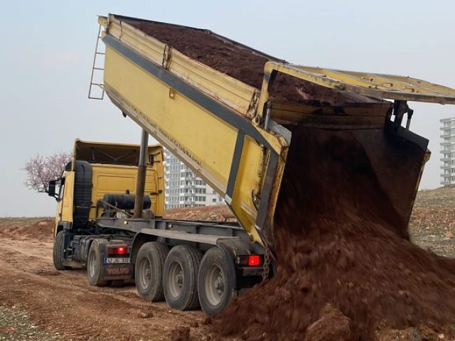 Mardin’de martaç hafriyat kapsamında toprak dökme işlemi yapan sarı kamyon.