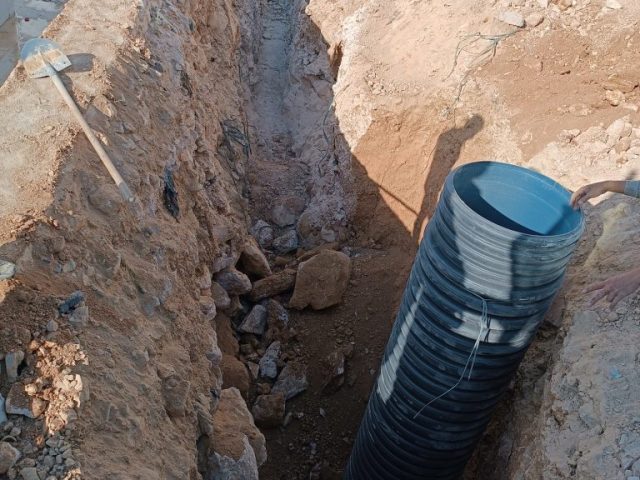 Mardin’de Martaç Hafriyat ekibi tarafından taş duvar yapımı için kazılan hendekte kum ve mıcır dolgu yerleştiriliyor.