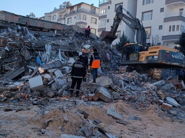 Martaç hafriyat Mardin ekibi enkaz kaldırma çalışması yapıyor, taş duvar ve kum zemin üzerinde mıcır kullanılarak alan temizleniyor.