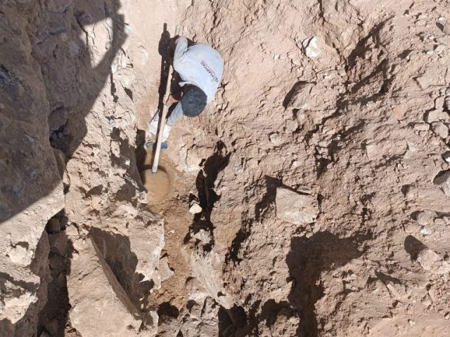 Mardin'de Martaç hafriyat işçileri, taş duvar kenarında kum ve mıcır dolgusu için derin hendekte kanal açma ve kazı işlemi gerçekleştiriyor.