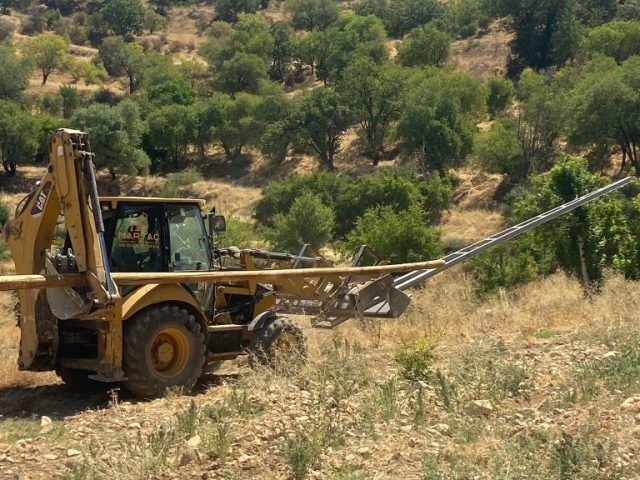 Martaç hafriyat iş makinesi mardin’de taş duvar kenarında arazi temizliği ve hafriyat yapıyor.