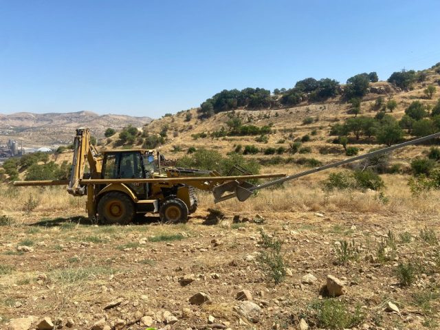 Martaç hafriyat iş makinesi mardin’in kırsalında taş duvarlı alanda hafriyat ve toprak taşıma işinde.