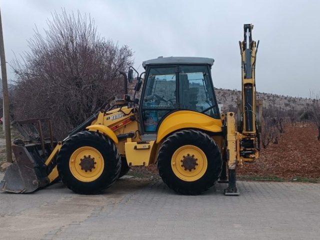 Mardin Martaç hafriyat firmasına ait iş makinesi, taş ve kum dolgu için duvar yanındaki çalışma alanında.